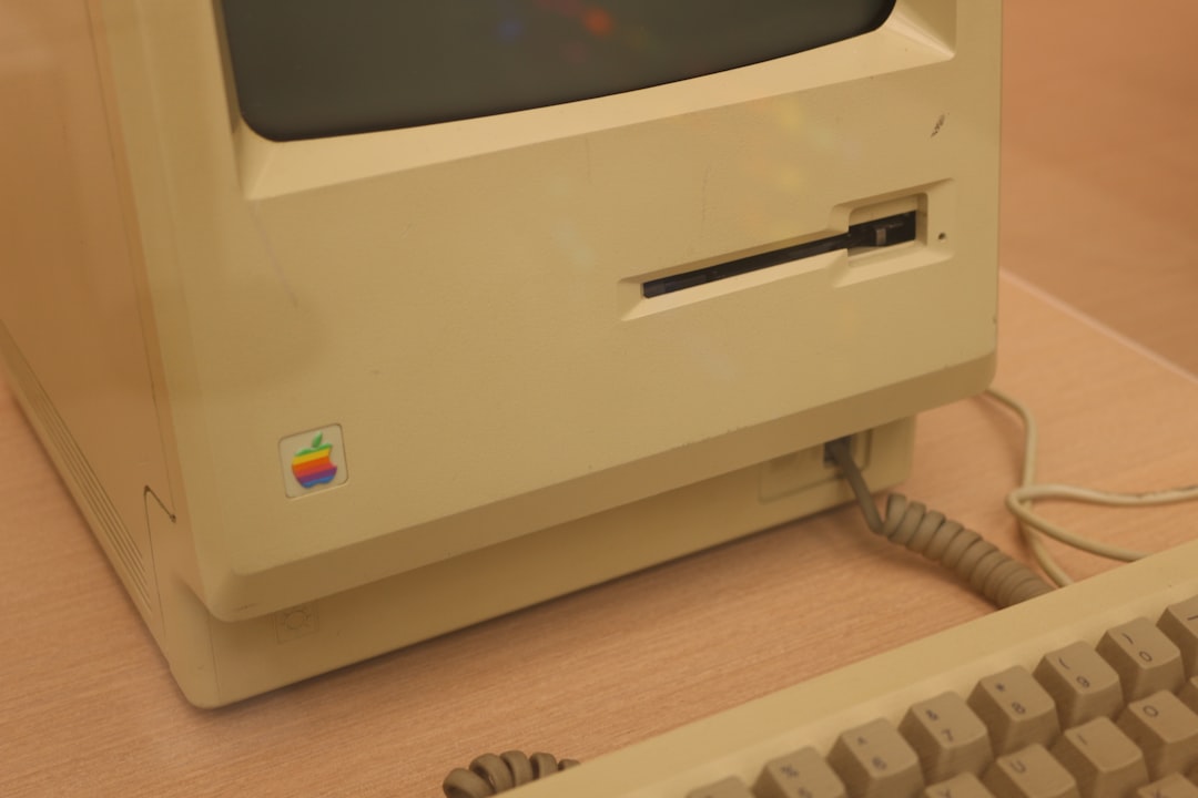 An old apple computer with a keyboard and mouse